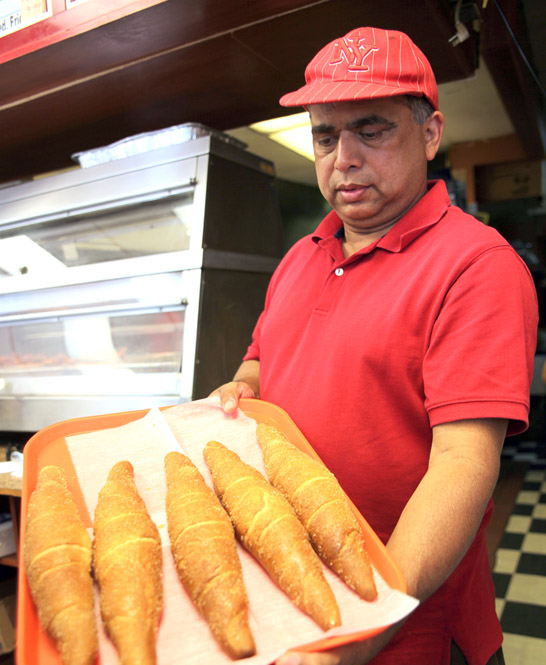 The owner of Papa's Chicken displays Sri Lankan baked goods. 