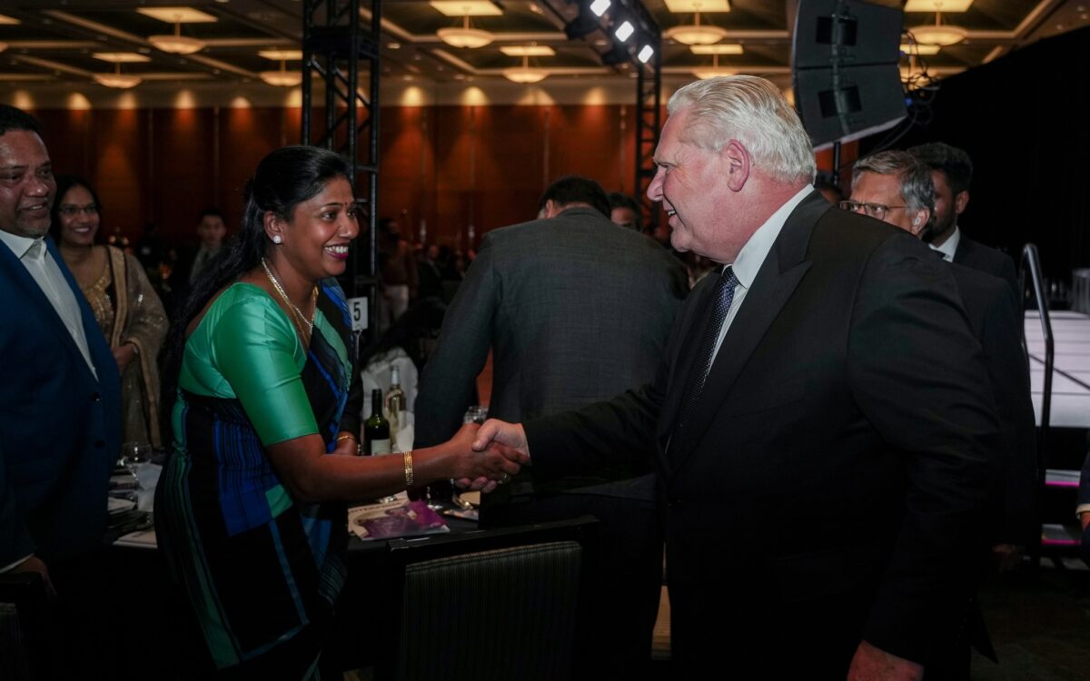 Premier Ford shakes hands with a woman at CTCC gala.