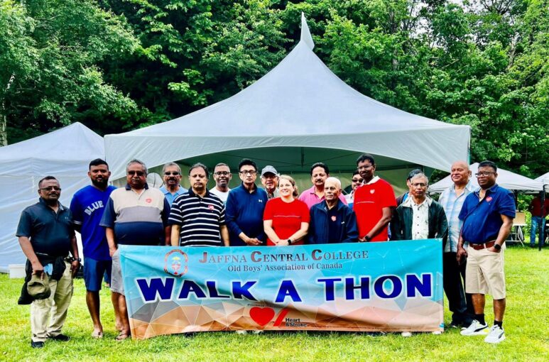 People hold giant banner in park for walk-a-thon.