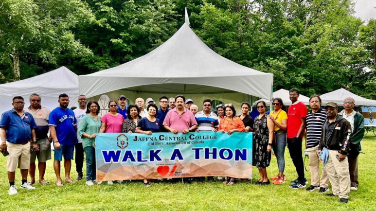 People hold giant banner in park for walk-a-thon.