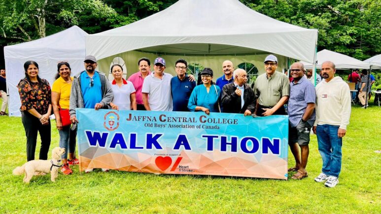 People hold giant banner in park for walk-a-thon.