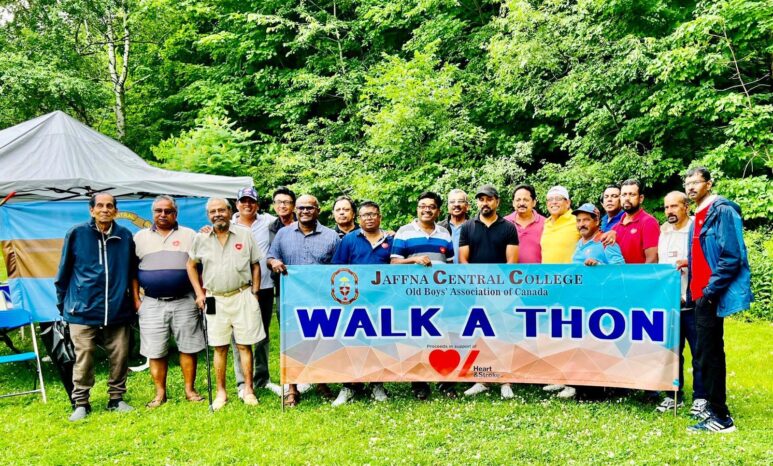 People hold giant banner in park for walk-a-thon.